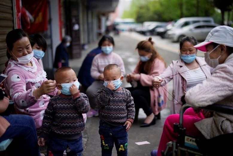 Children and women wearing face masks are seen in Xianning. REUTERS/Aly Song